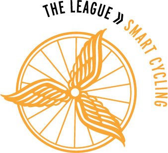 Logo of the League of American Bicyclists Smart Cycling program, a gold wheel with three wings equally spaced along the spokes