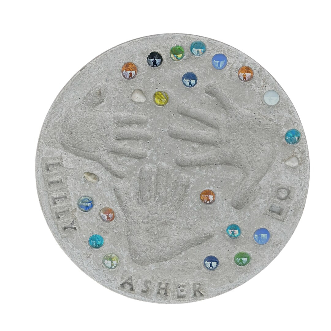 Image of a grey stone with hand prints, gem stones, and the names "Lilly" and "Asher".